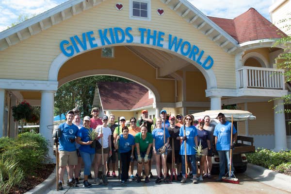 Group of volunteers posing for photo in front of Give Kids the World sign