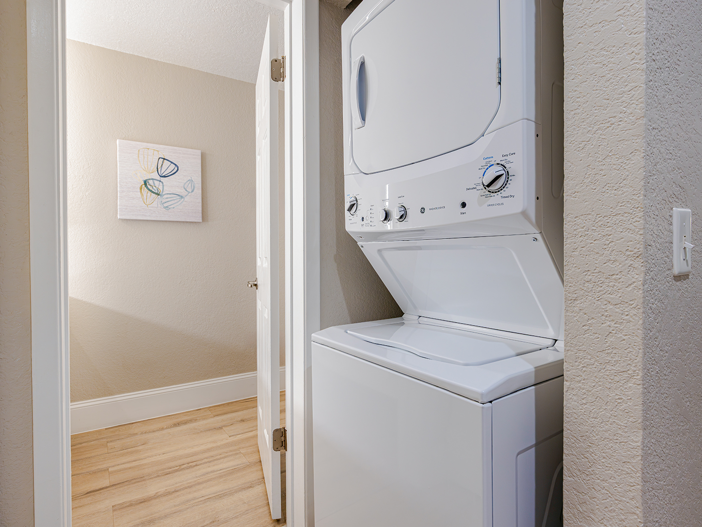 In-unit laundry closet with a stacked washer and dryer.