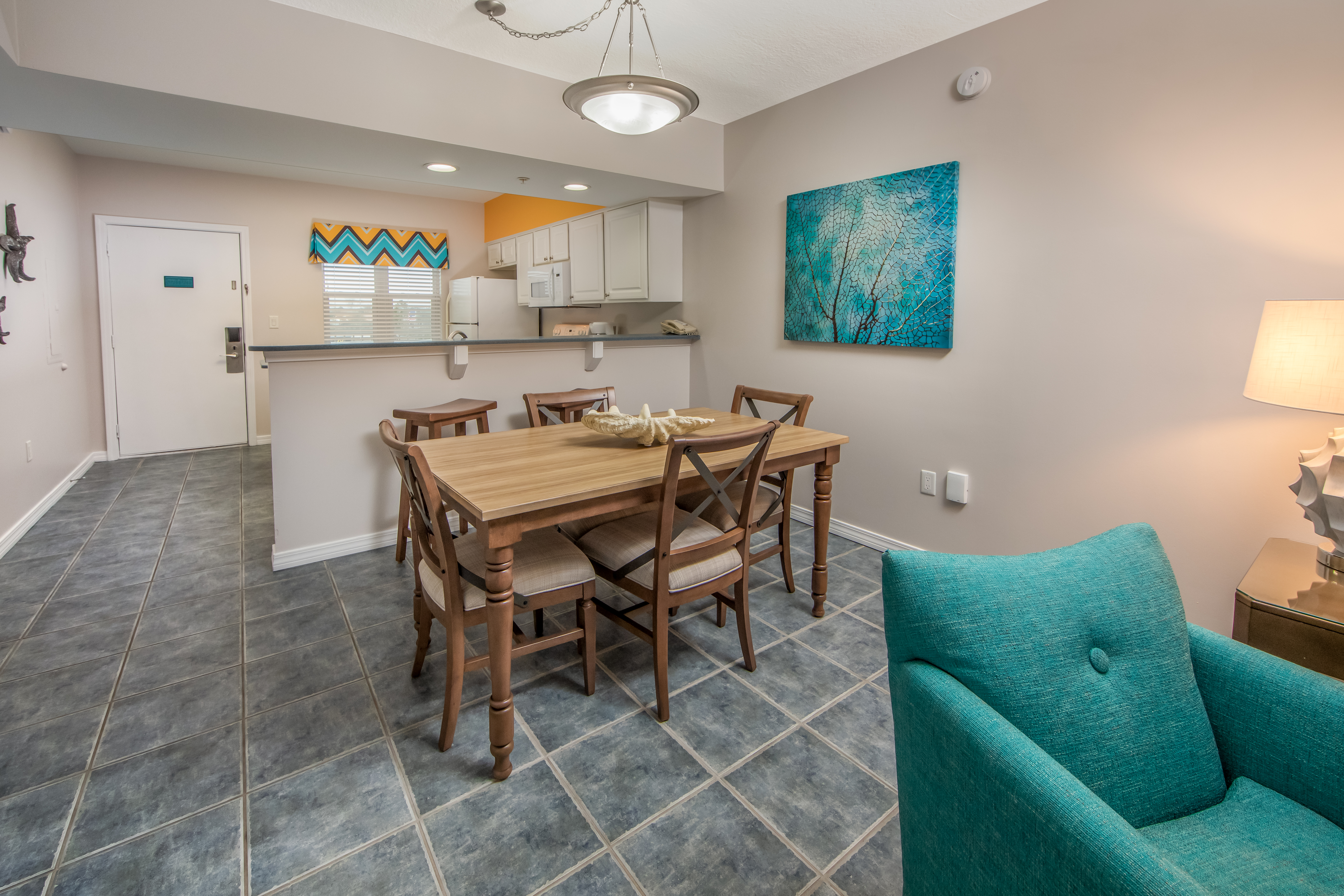 Dining room with table and five chairs in a one-bedroom villa at Panama City Beach Resort
