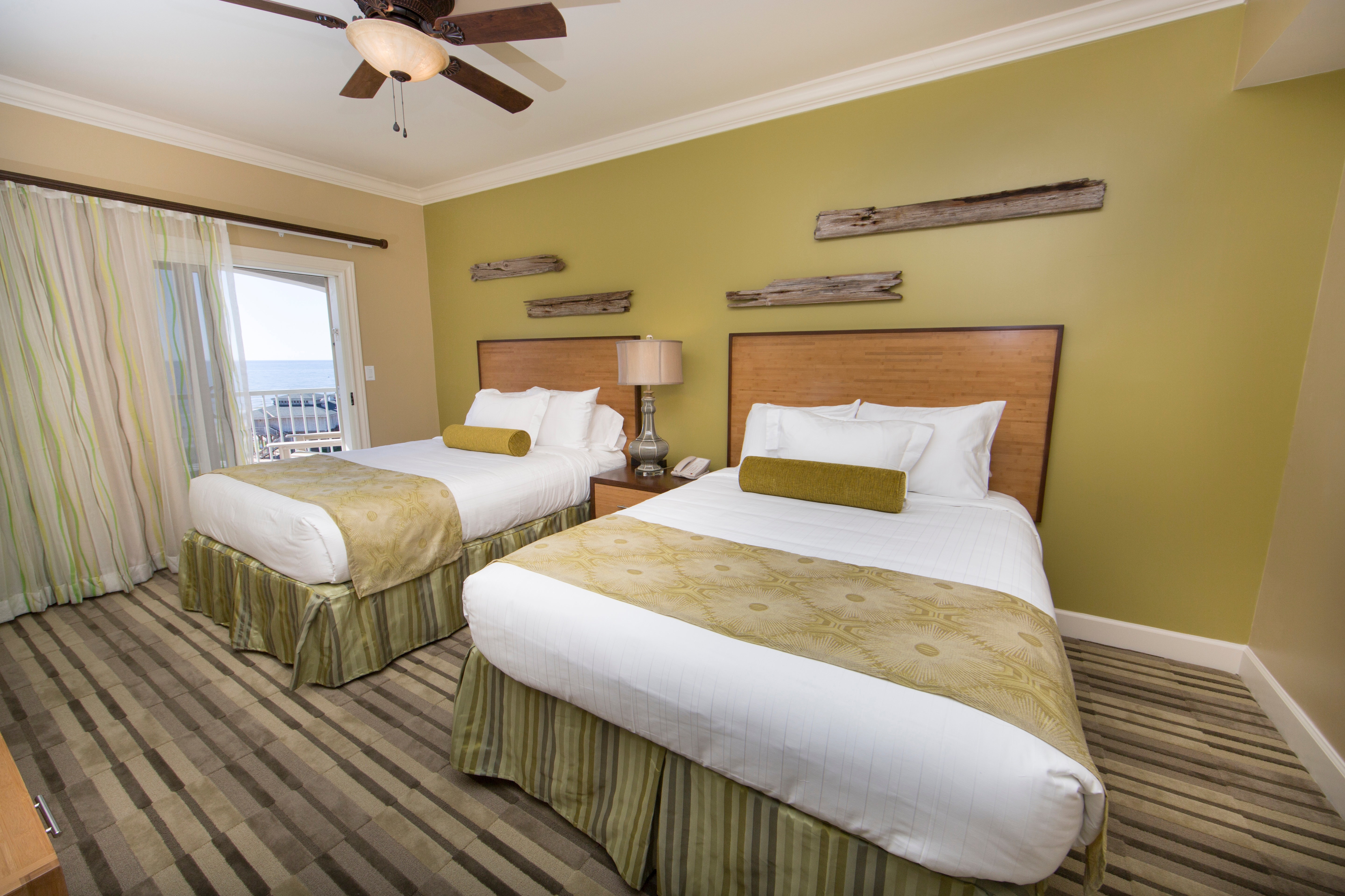 Guest bedroom with two beds and access to the balcony in a Signature two-bedroom villa at Galveston Beach Resort