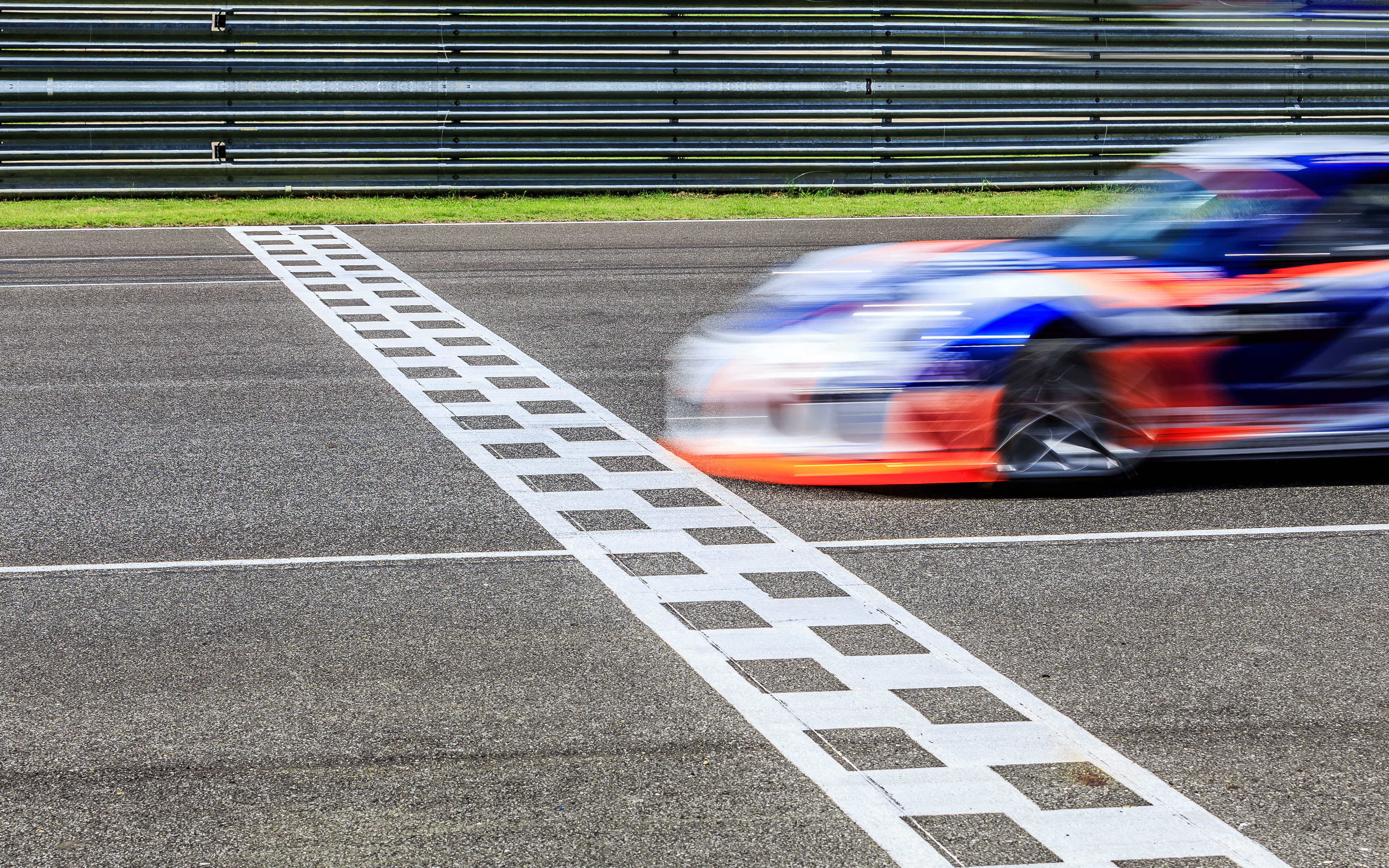 Race car crossing finish line at a race.