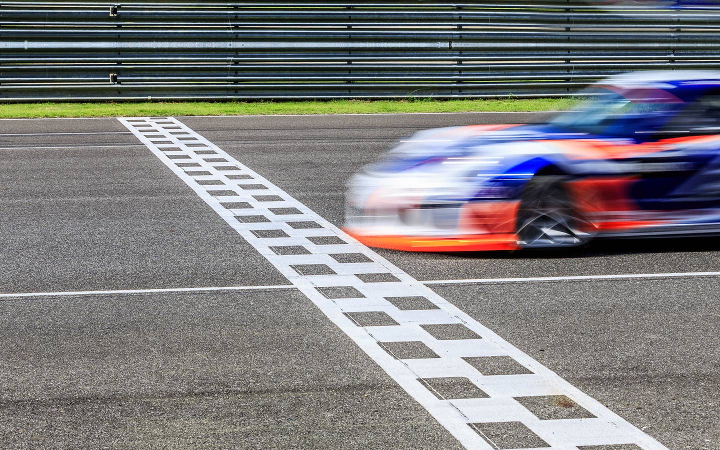 Race car crossing finish line at a race.