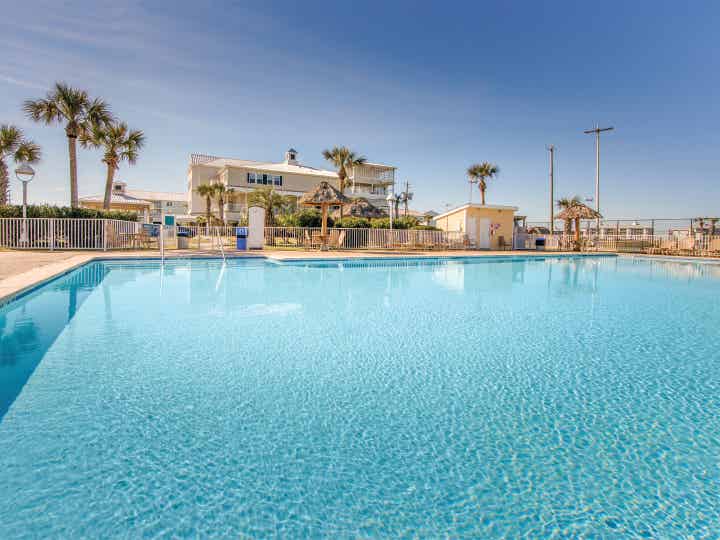 Outdoor pool surrounded by palm trees at Galveston Seaside Resort.