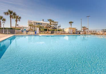 Outdoor pool surrounded by palm trees at Galveston Seaside Resort.