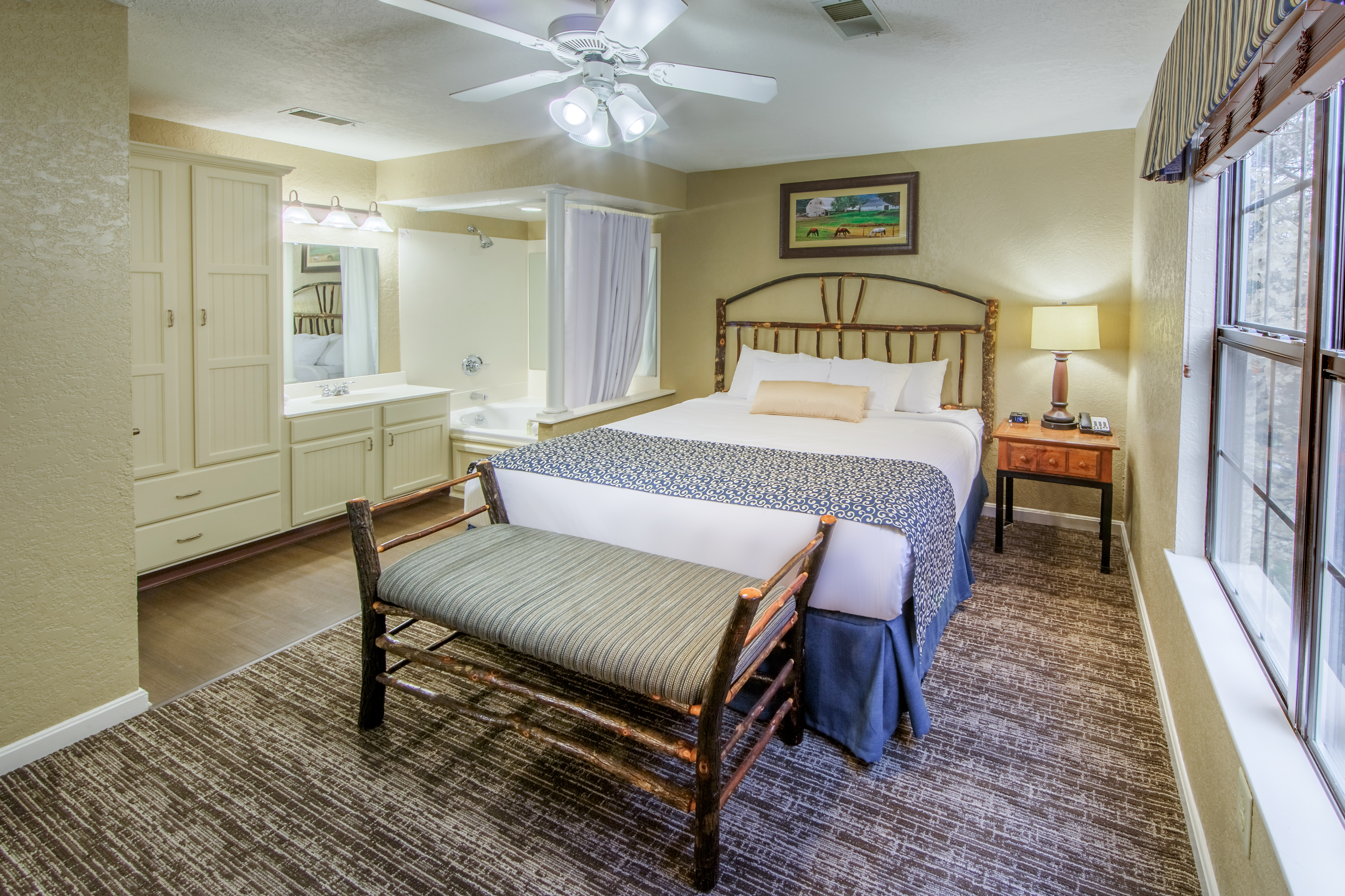 Master bedroom with in-room tub and vanity in a two bedroom villa at Oak n' Spruce Resort in South Lee, Massachusetts