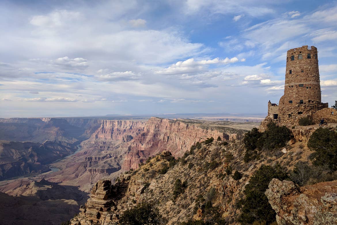 A worn, brick watch tower overlooks the Grand Canyon.