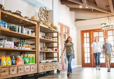 Family of three walking into Marketplace with souvenirs and vacation essentials at Scottsdale Resort.