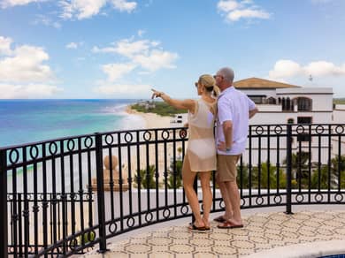 Couple looking at ocean from balcony