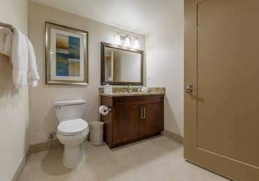 Bathroom with toilet and sink with mirror in a three-bedroom villa at Scottsdale Resort