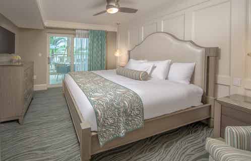 Bedroom with king bed and access to a furnished balcony in a two-bedroom Signature villa at Cape Canaveral Beach Resort