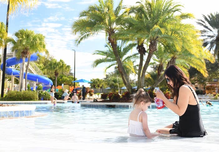 Woman and child sitting in lazy river.