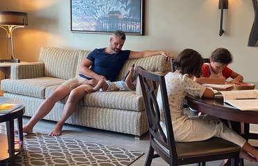 Brenda's family sits in their villa with work and play.