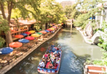 view of the sidewalk and riverboat at the San Antonio River near Hill Country Resort