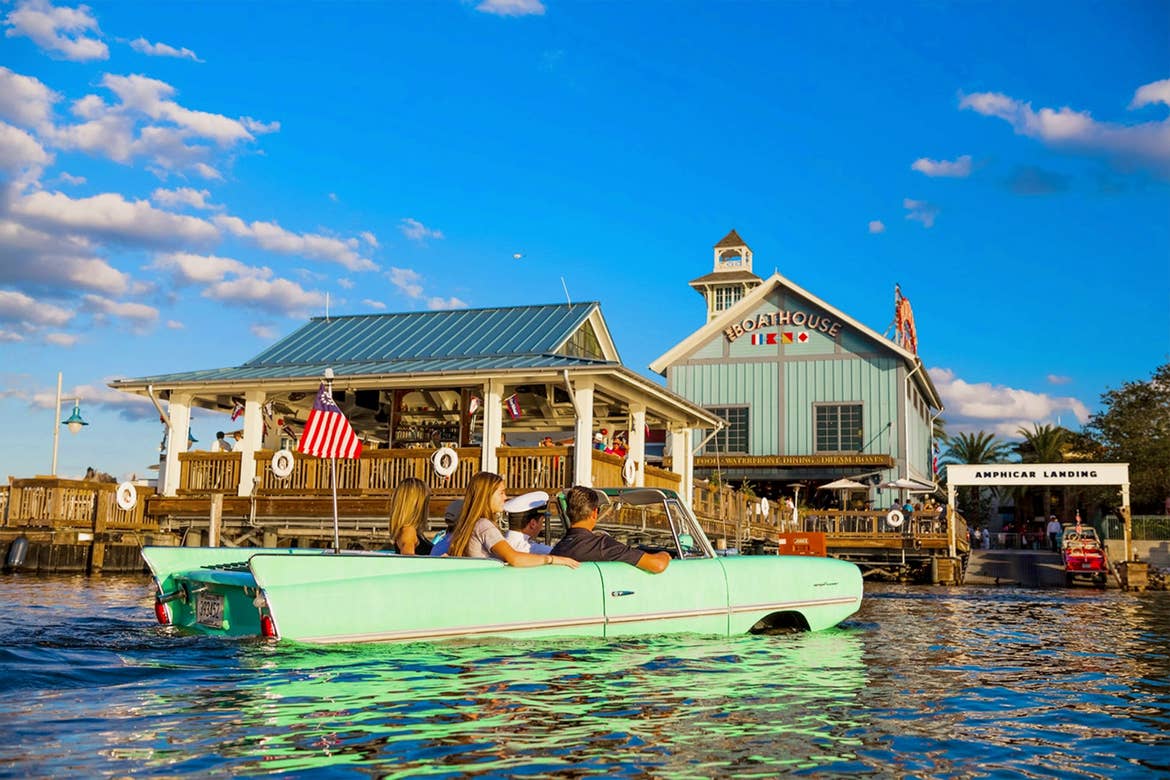 Guests ride in an amphibious automobile known as the 'Amphicar' outside of The BOATHOUSE Orlando located at Disney Springs.