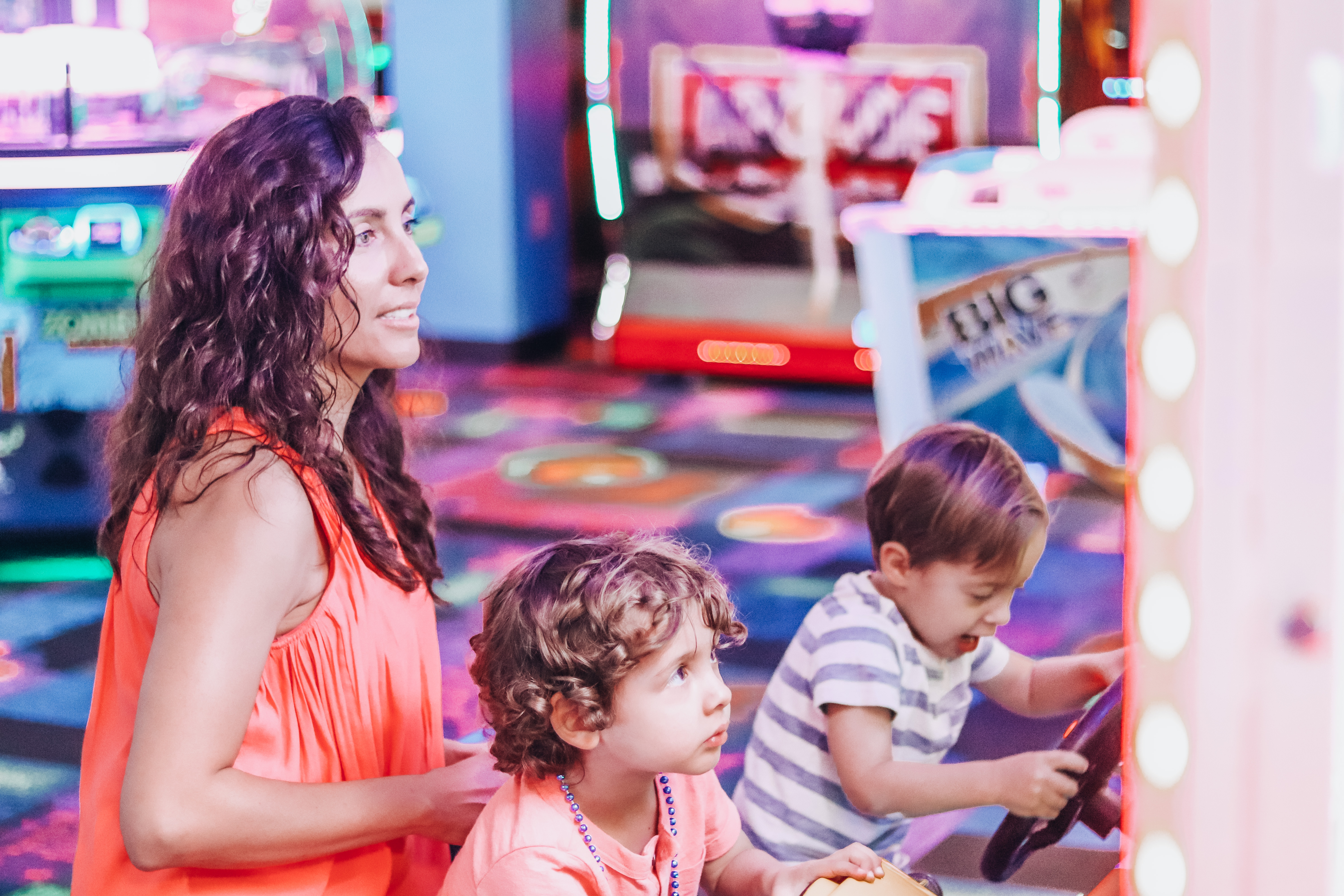 Raff's wife and two kids playing video games at the arcade.