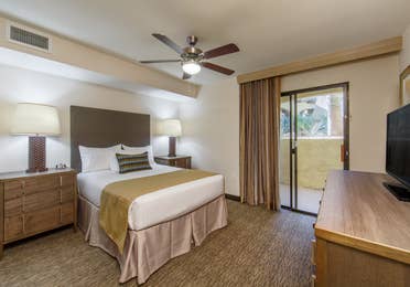Guest bedroom with balcony access and flat screen TV in a three-bedroom villa at Scottsdale Resort