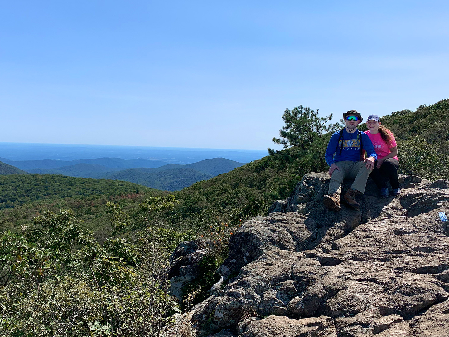 Featured Contributor, Ashley Fraboni (right) and Fiancé, Nicholas (left) sit atop a rock a Shenandoah National Park.