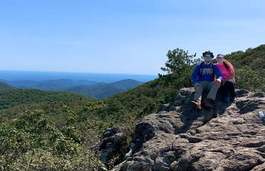 Featured Contributor, Ashley Fraboni (right) and Fiancé, Nicholas (left) sit atop a rock a Shenandoah National Park.