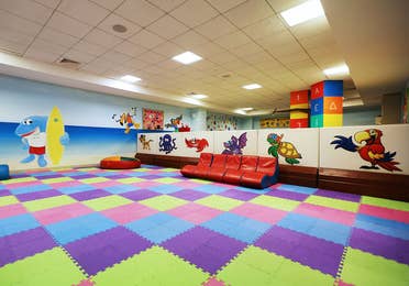 Game room with colorful foam flooring play area, red gaming chairs and a kid zone area at The Royal Haciendas in Playa del Carmen, Mexico