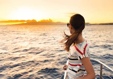 Woman standing on yacht looking out into the sunset