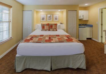 Bedroom with king bed and kitchenette in a presidential two bedroom villa at Piney Shores Resort in Conroe, Texas