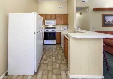 Kitchen with fridge, oven, microwave, and sink in a two-bedroom cabin at Ozark Mountain Resort in Kimberling City, Missouri