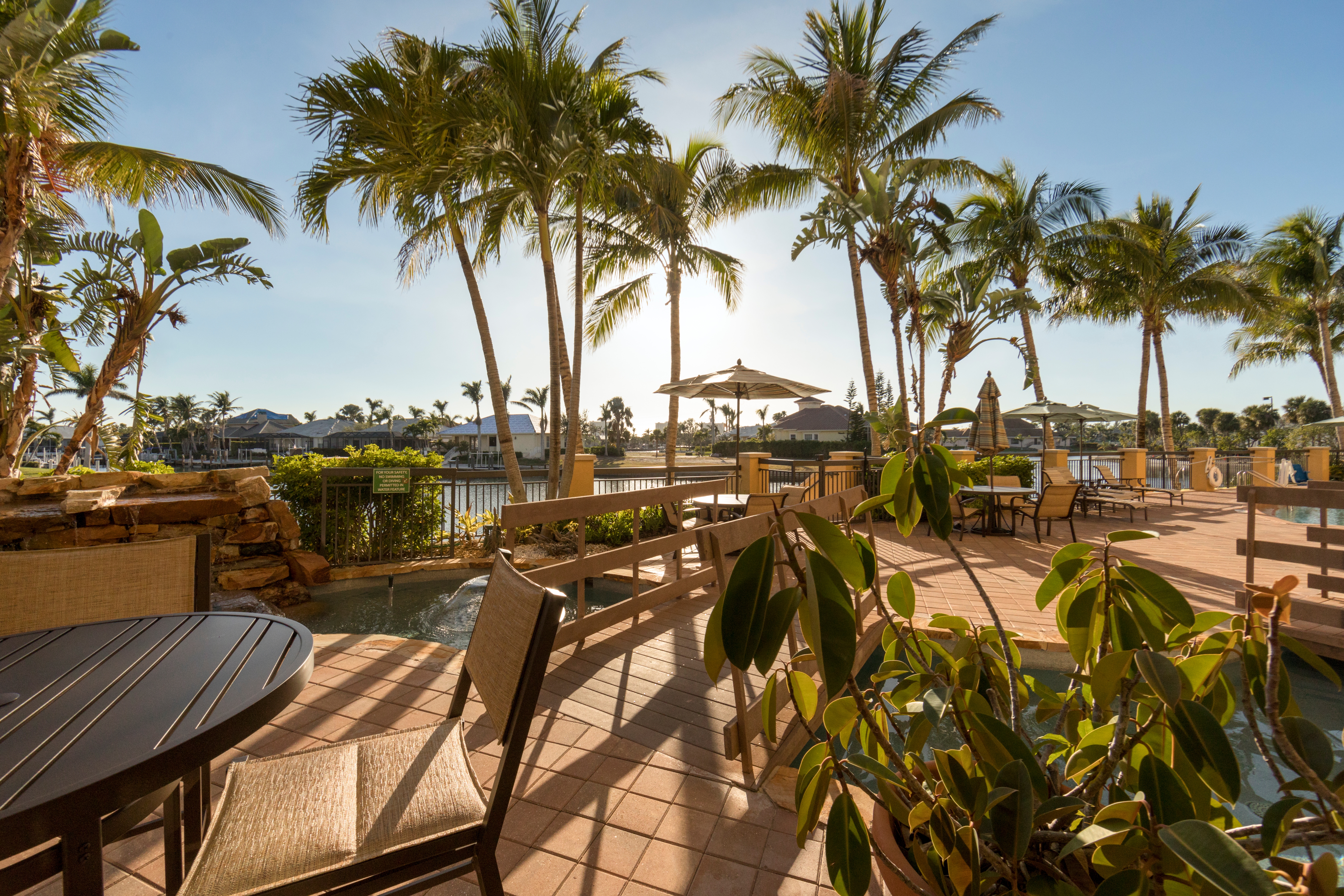 Outdoor seating with views of palm trees at Sunset Cove Resort in Marco Island, Florida.