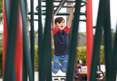 Young boy on monkey bars at Orange Lake Resort near Orlando, Florida