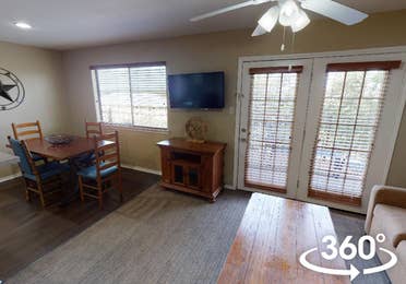 Two-bedroom townhome villa with couch, flat screen TV and dining area at Hill Country Resort in Canyon Lake, Texas.