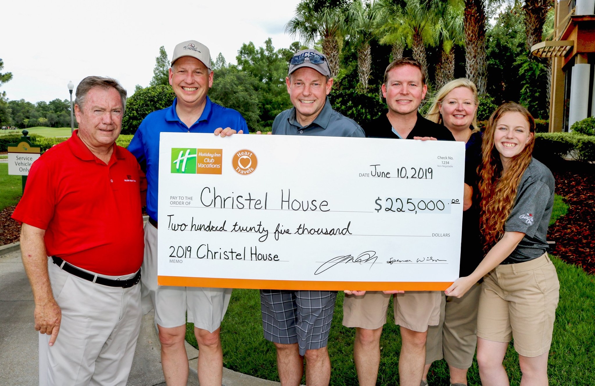 Group of people holding a large presentation check for $225,000 made payable to Christel House