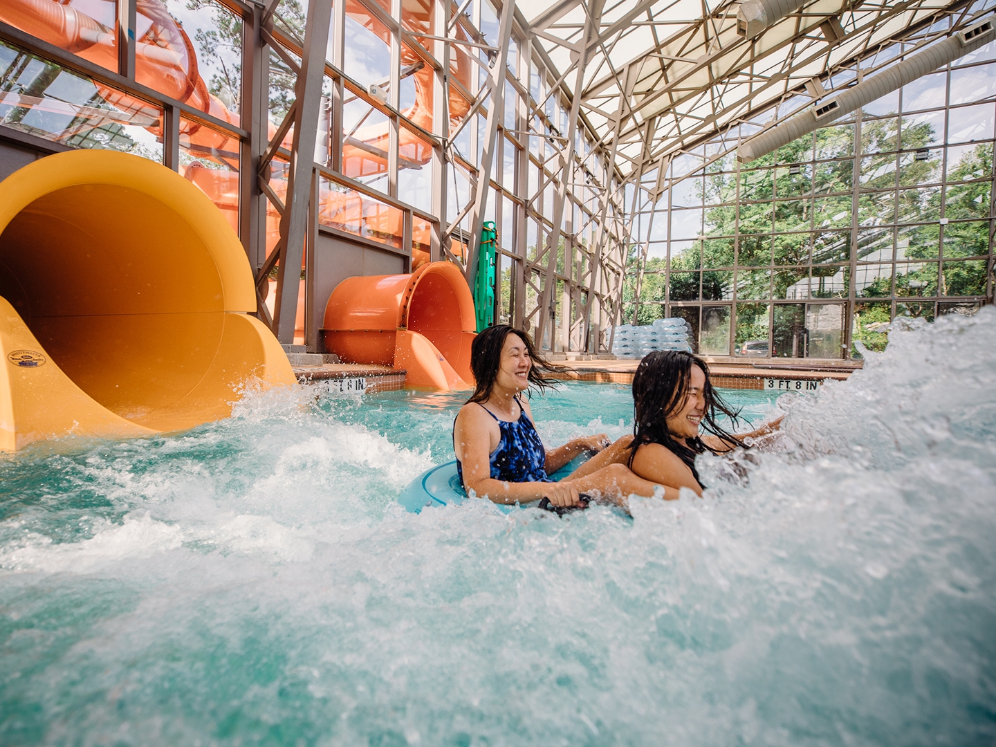 Two guests sliding down waterslide at Waterpark at Villages Resort in Flint, Texas.