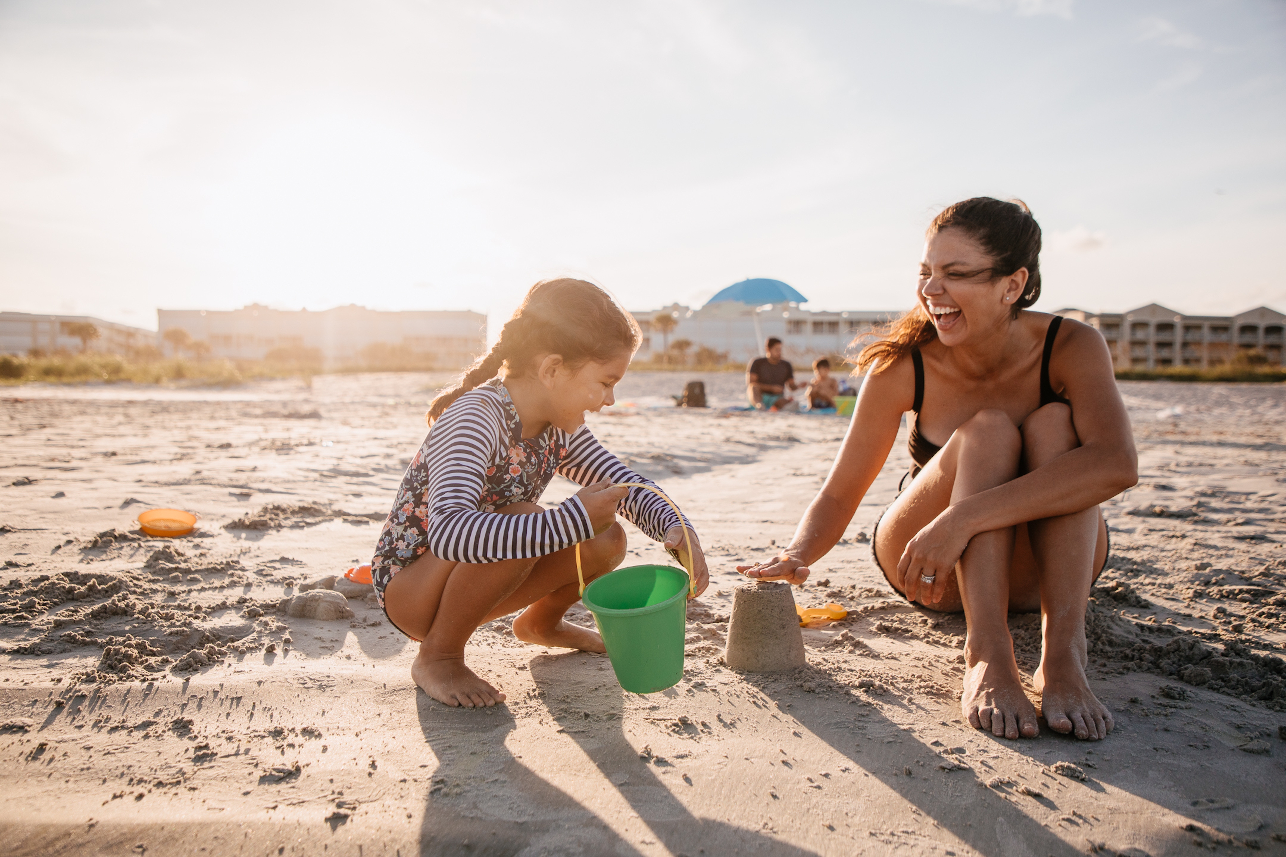 Mother and child playing in sand at Cape Canaveral Beach Resort in Florida.