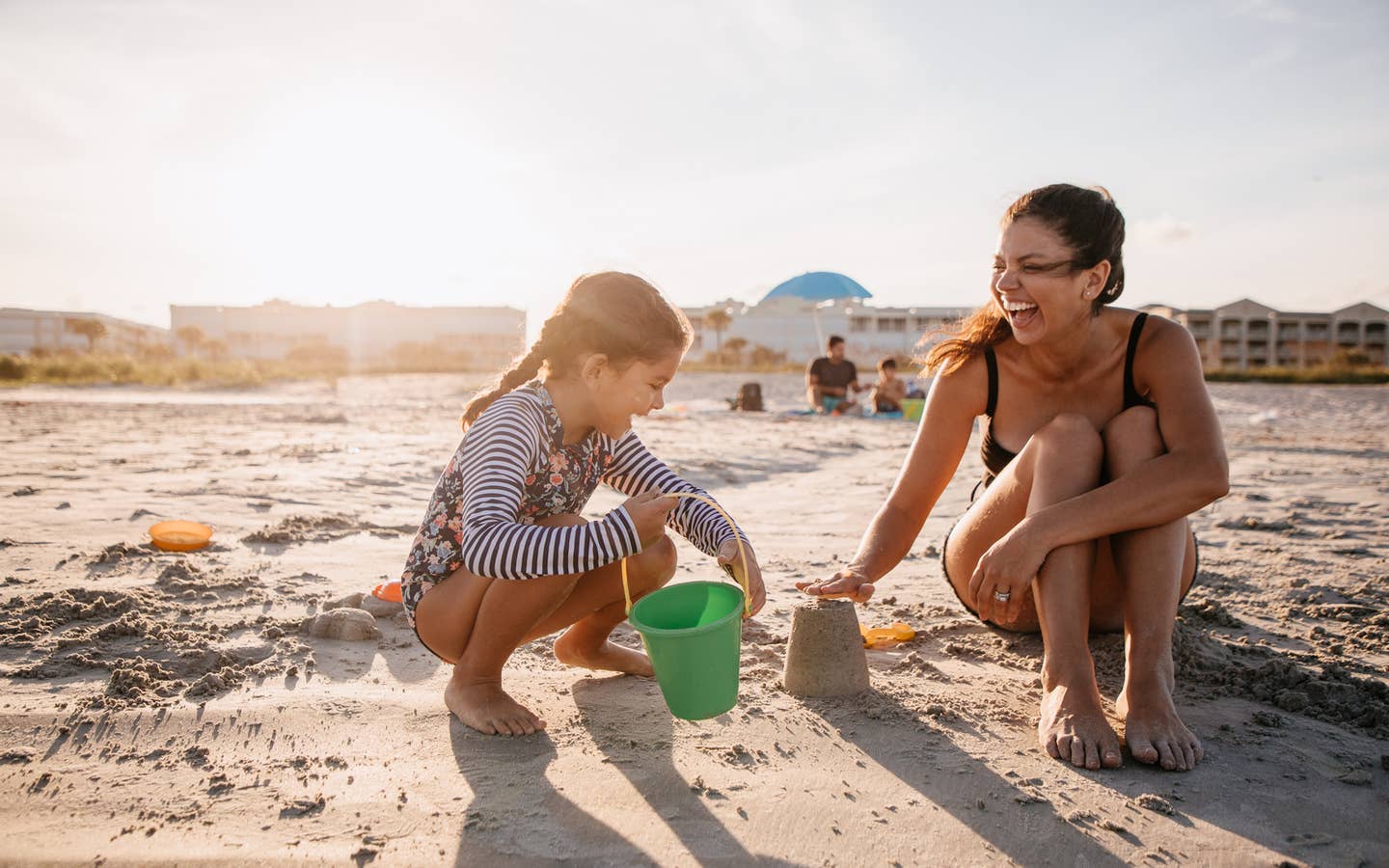 Mother and child playing in sand at Cape Canaveral Beach Resort in Florida.