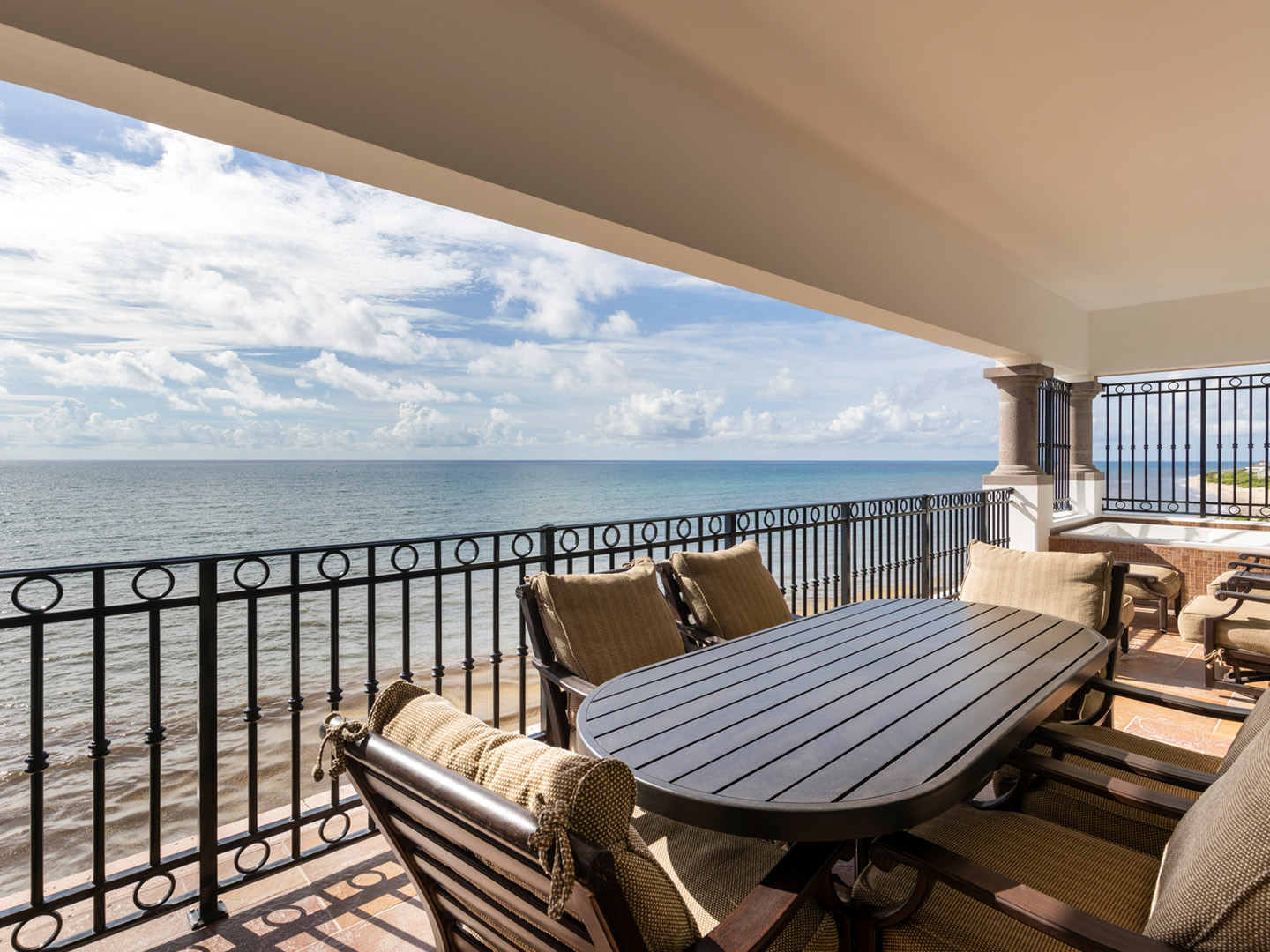 Oceanfront balcony with plush seating and panoramic sea views.