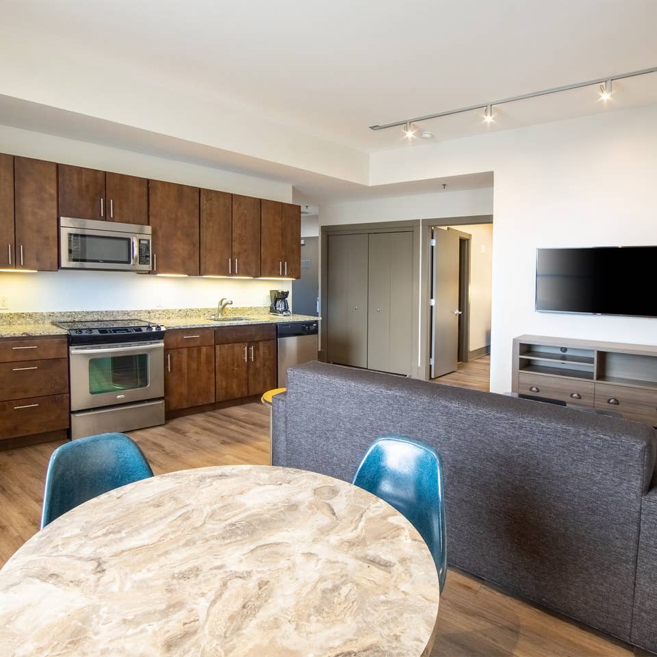 One bedroom villa living room with full kitchen, dining area, couch and TV at New Orleans Resort in Louisiana.