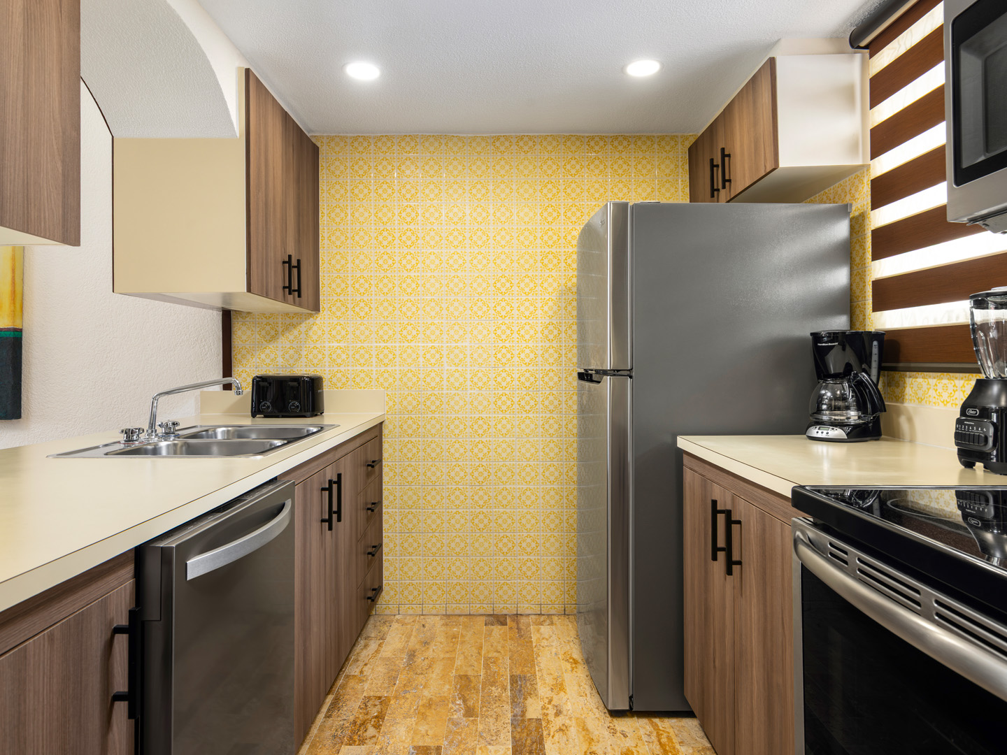 Bright villa kitchen with stove, fridge, and cabinets.