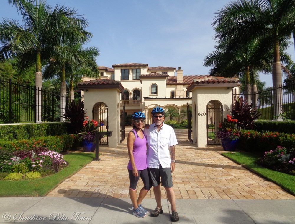 Denise and CJ with helmets on posing in front of a mansion on Marco Island