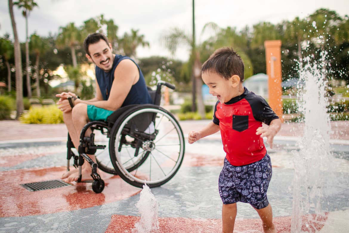 Author, Danny Pitaluga (left), and son, Joey (right), wear their swimsuits near a fountain park area at our Orange Lake Resort located in Orlando, Florida.
