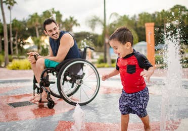 Author, Danny Pitaluga (left), and son, Joey (right), wear their swimsuits near a fountain park area at our Orange Lake Resort located in Orlando, Florida.