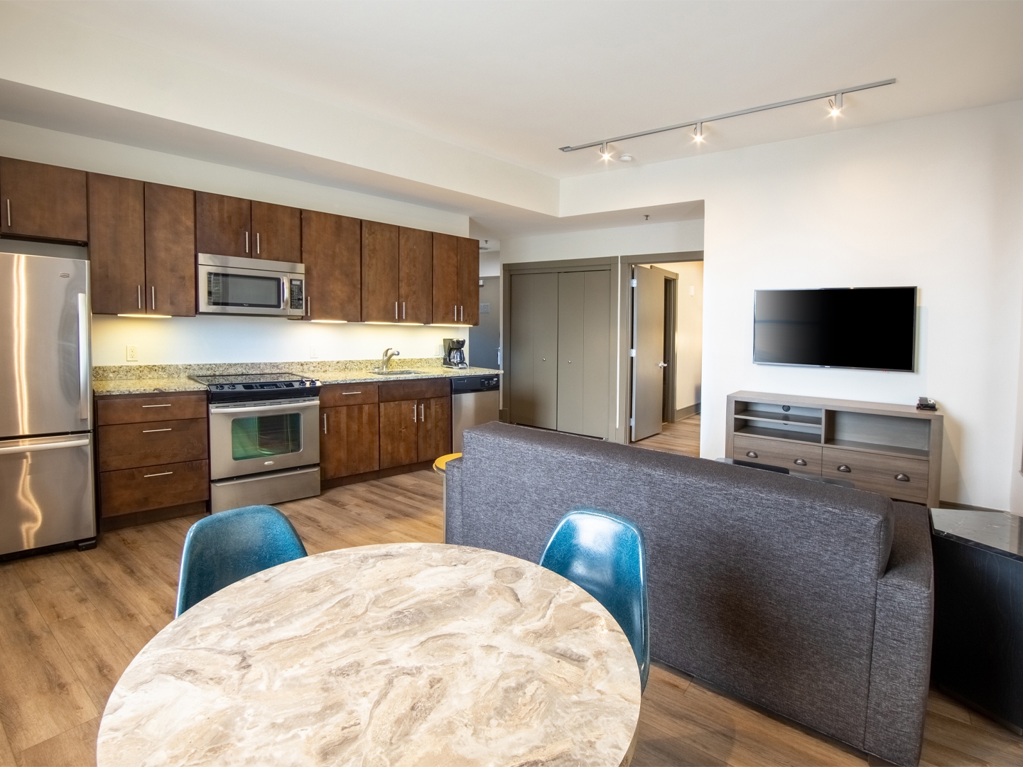 One bedroom villa living room with full kitchen, dining area, couch and TV at New Orleans Resort in Louisiana.