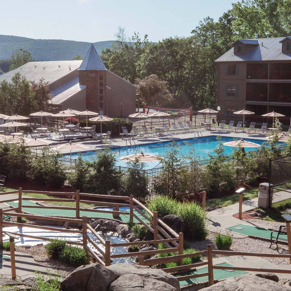 Property shot of Oak n' Spruce Resort with an outdoor pool, mini golf course and property building in South Lee, Massachusetts.