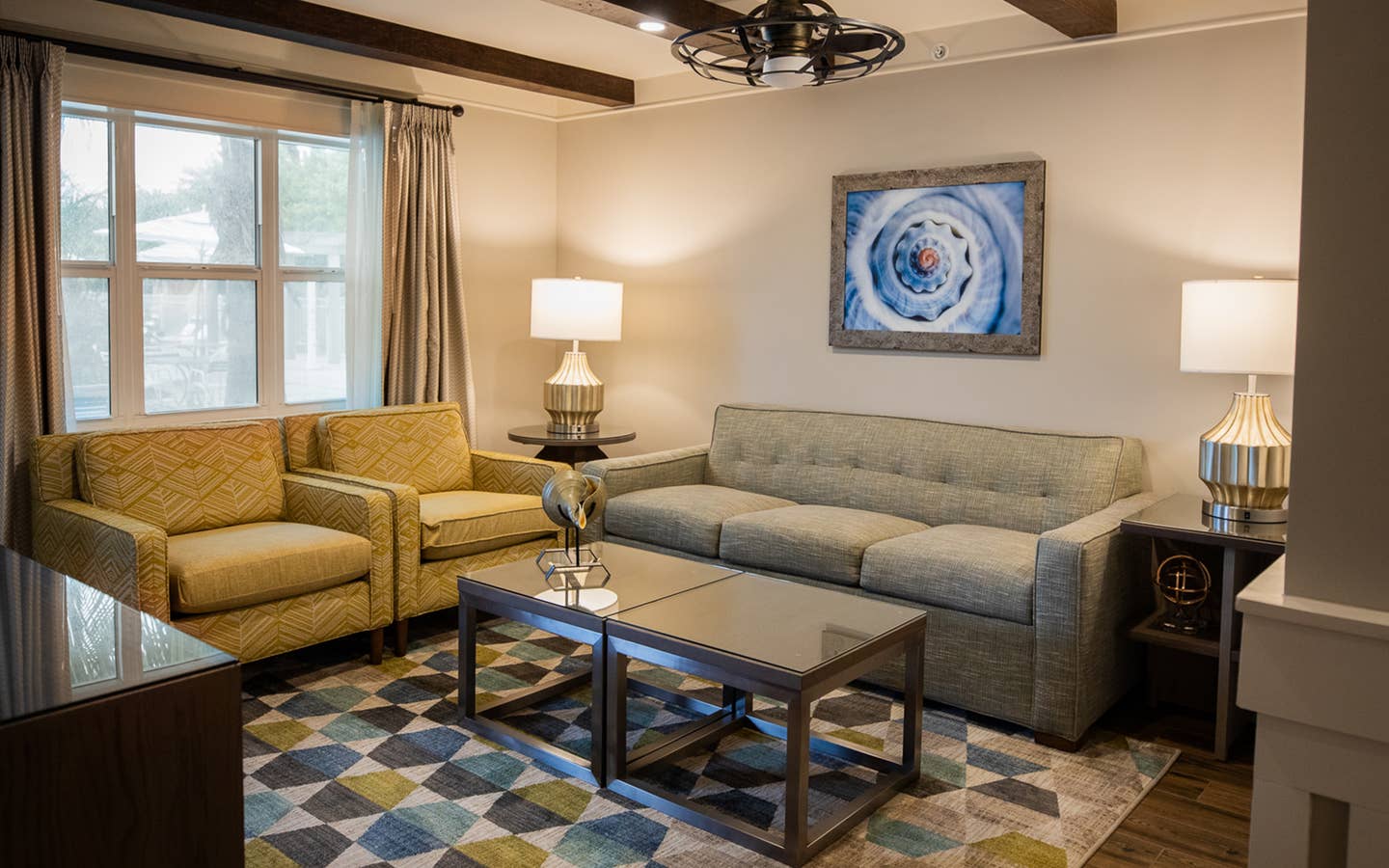 Living room with couch and two chairs in a two-bedroom Signature Collection villa at Cape Canaveral Beach Resort.