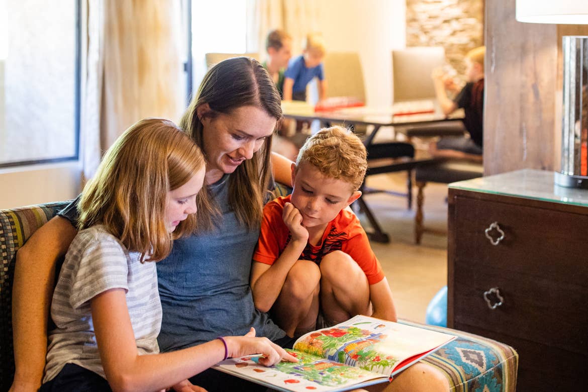 Author Jessica Averett (middle) sits in their villa reading to her daughter (left) and son (right) at our Scottsdale Resort.
