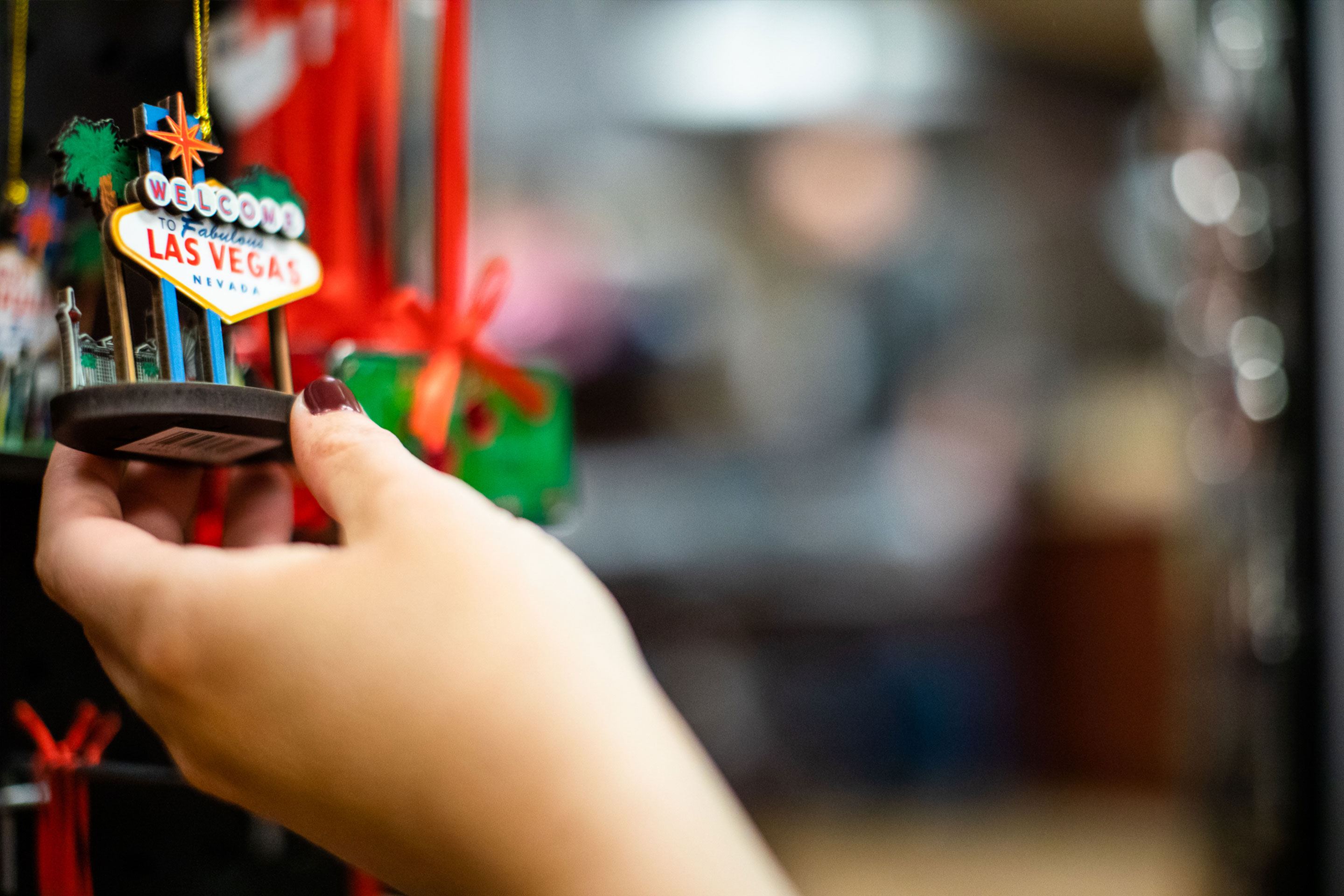 Someone holds a Las Vegas marquee ornament that reads 'Welcome to Las Vegas Nevada."