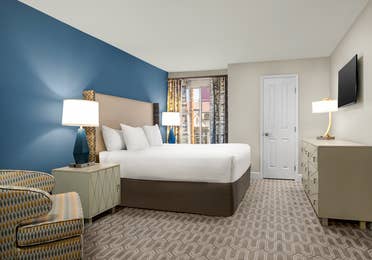 Bedroom with king bed, modern decor, and natural light.