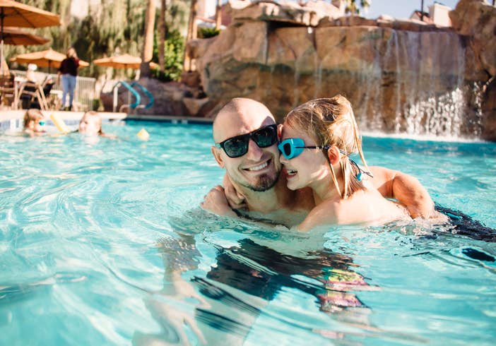 Father and daughter in Watering Hole outdoor pool at Desert Club Resort in Las Vegas, Nevada.