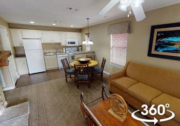 Two-bedroom lodge villa with couch, dining area and kitchen at Hill Country Resort in Canyon Lake, Texas.