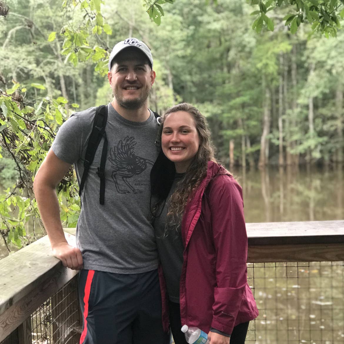 Featured Contributor, Ashley Fraboni (right) and Fiancé, Nicholas (left) sit on a bridge at Congaree National Park.