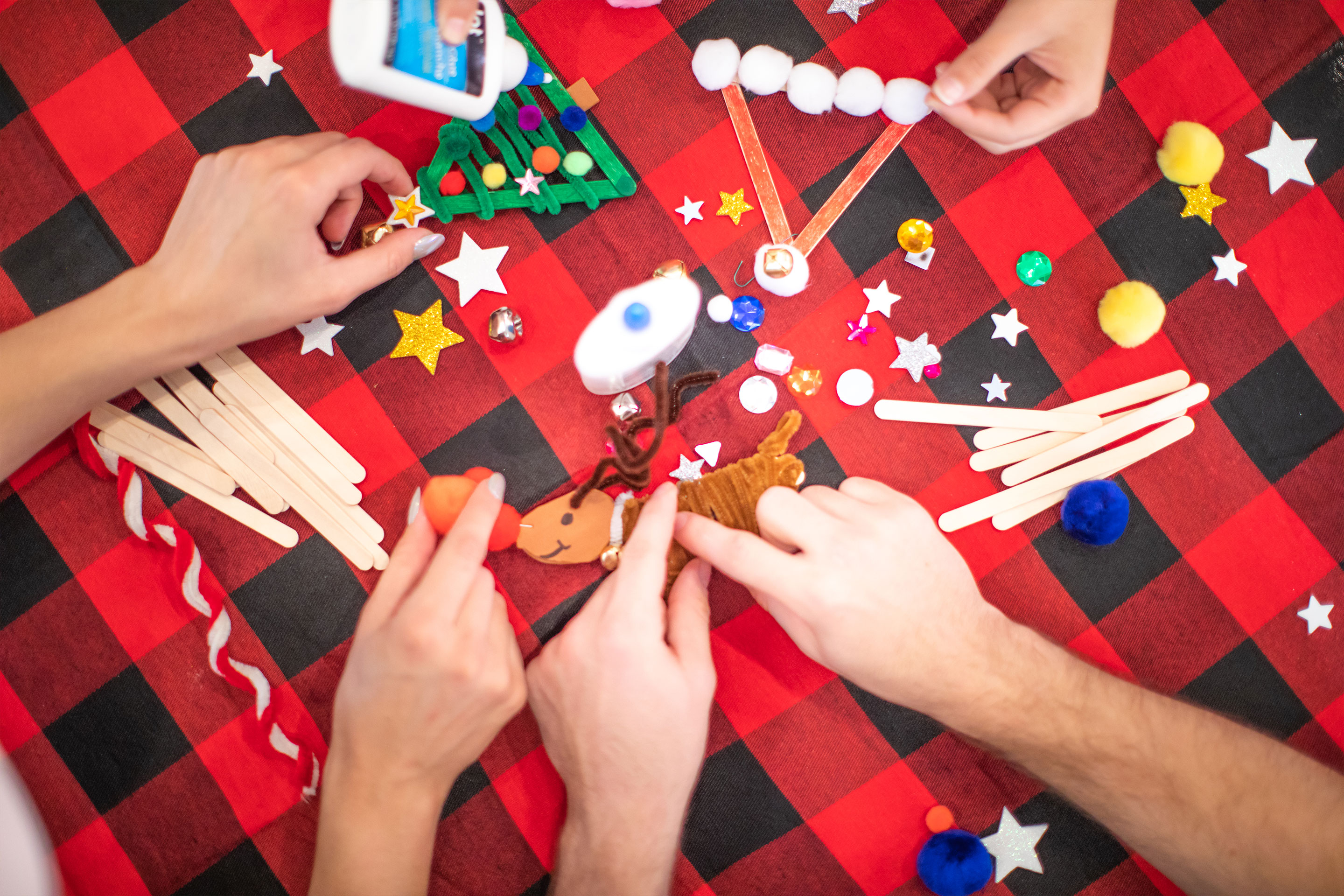 A Jollydays craft activity with various supplies to make Christmas tree ornaments.