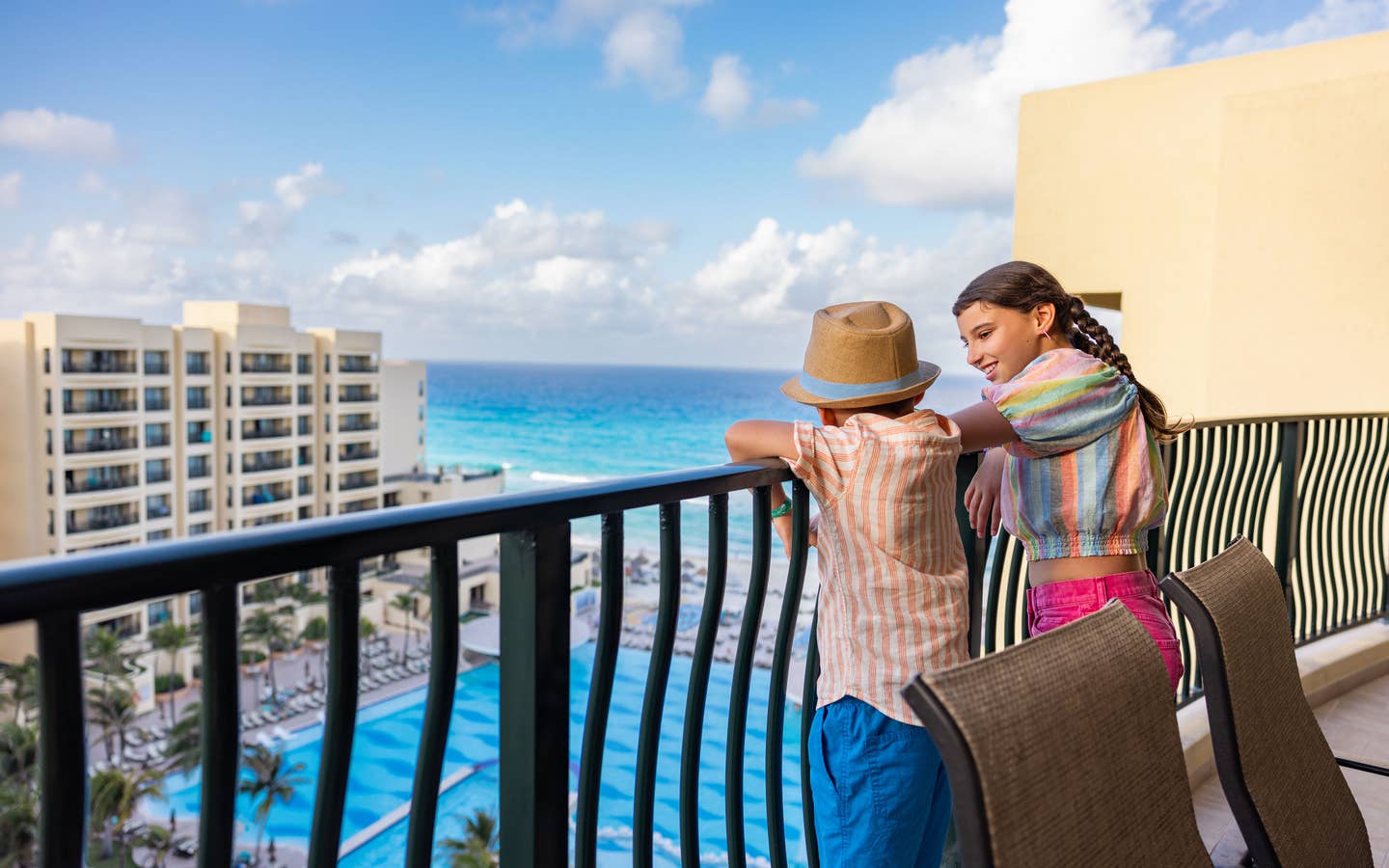 Kids on a balcony overlooking the pool and ocean at Royal Sands Resort.